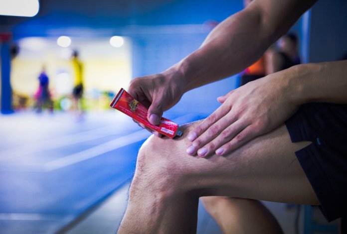A,Fitness,Man,Applying,Ointment,Cream,(lotion),Onto,His,Knee